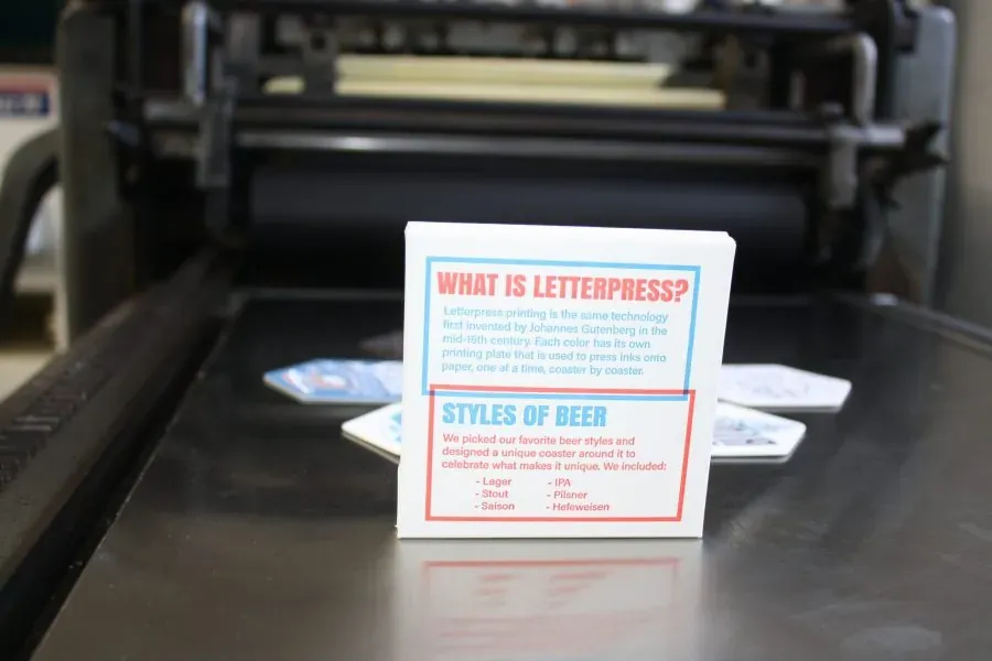 A letterpress printed beer coaster set box on the bed of a press